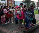 Indigenous people wearing protective face masks as a preventive measure against the spread of the coronavirus disease (COVID-19) carry their belongings after being evicted from a building in Bogota, Colombia.