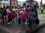 Indigenous people wearing protective face masks as a preventive measure against the spread of the coronavirus disease (COVID-19) carry their belongings after being evicted from a building in Bogota, Colombia.