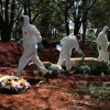 Gravediggers wearing protective suits are seen as one of then tightens a screw on the coffin of someone who died suspected to have had coronavirus disease (COVID-19), at Vila Formosa cemetery, Brazil's biggest cemetery, in Sao Paulo, Brazil.