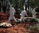 Gravediggers wearing protective suits are seen as one of then tightens a screw on the coffin of someone who died suspected to have had coronavirus disease (COVID-19), at Vila Formosa cemetery, Brazil's biggest cemetery, in Sao Paulo, Brazil.