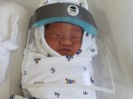 A newborn baby is seen in a hospital wearing a protective face shield during the coronavirus disease (COVID-19) outbreak in Bangkok