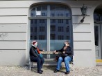 Two woman chat on a bench while practicing social distancing as the spread of the coronavirus disease (COVID-19) continues in Berlin
