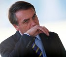 Brazil's President Jair Bolsonaro gestures while meeting supporters as he arrives at Alvorada Palace, amid the coronavirus disease (COVID-19) outbreak, in Brasilia