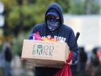 A man carries away fresh food at a Los Angeles Regional Food Bank giveaway 