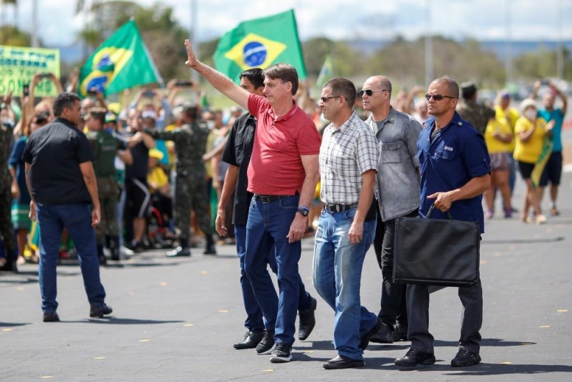 Brazil's President Jair Bolsonaro gestures after joining his supporters, who were taking part in a motorcade to protest against quarantine and social distancing measures, amid the COVID-19 outbreak, in Brasilia, Brazil.