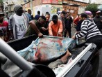 Residents carry dead bodies after a police operation against drug gangs in Rio de Janeiro