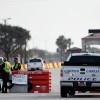 Police officers stand at a checkpoint after a shooting incident at Naval Air Station Corpus Christi