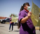 A woman holds a sign that reads 