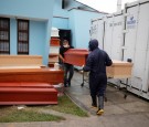 Workers carry a coffin outside of the crematorium at Angel Cemetery, where victims of COVID-19 are cremated in Lima, Peru.