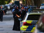 Police officers wearing protective equipment gather at the scene of a shooting incident in Darmstadt