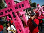 Women carry pink crosses during the 