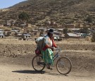 An indigenous woman cycles nears Cohana Bay on the shores of Titicaca lake, some 110 km (68 miles) northwest of La Paz