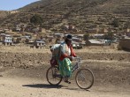 An indigenous woman cycles nears Cohana Bay on the shores of Titicaca lake, some 110 km (68 miles) northwest of La Paz