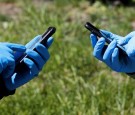 People wearing protective gloves use their smartphones amid the coronavirus disease outbreak in Kiev