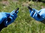 People wearing protective gloves use their smartphones amid the coronavirus disease outbreak in Kiev