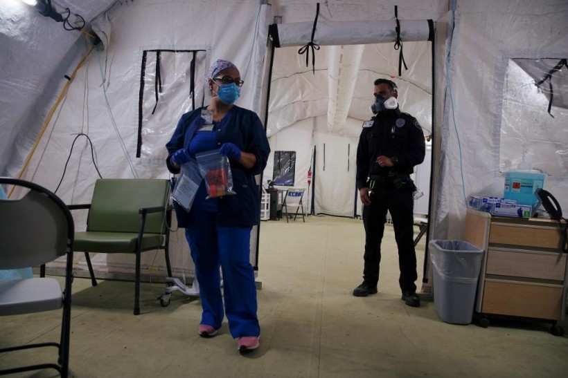 A healthcare worker and a security guard stand inside a newly expanded makeshift triage center outside the El Centro Regional Medical Center where suspected patients of the COVID-19 are being treated in El Centro, California, US.