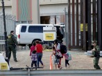 CBP agents look at migrants who crossed illegally into El Paso, Texas, U.S. to turn themselves in to ask for asylum as seen from Ciudad Juarez