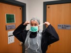 Doctor Nathalie Dukes puts on personal protective equipment (PPE)