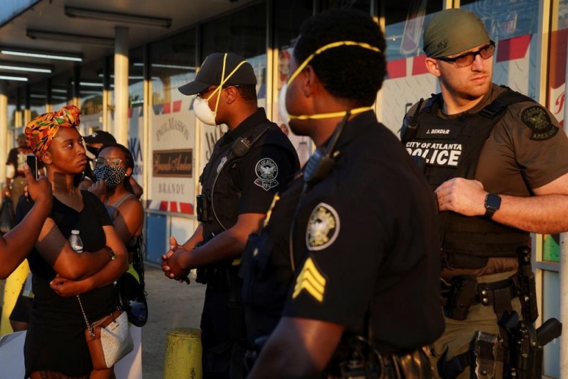 Police officers speak with a protester during a rally against racial inequality and the police shooting death of Rayshard Brooks, in Atlanta, Georgia, US.
