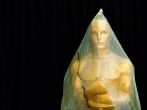 An Oscar statue stands covered with plastic during preparations leading up to the 87th Academy Awards in Hollywood, California