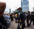 An Austin police officer points his weapon after protesters threw rocks and bottles during a rally against the death in Minneapolis police custody of George Floyd, in Austin, Texas, US