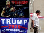 A man walks past banners of U.S. President Donald Trump near the BOK Center in Tulsa