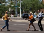People cross the street between Kierland Commons and Scottsdale Quarter with and without face coverings, during the global outbreak of the coronavirus disease (COVID-19), in Scottsdale