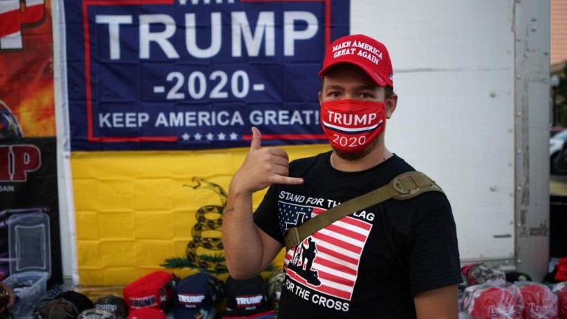 A supporter of U.S. President Donald Trump gestures while wearing a mask outside the BOK Center, the venue for Trump's upcoming rally, in Tulsa, Oklahoma, US.