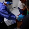 Volunteer paramedic, Kevin Garcia, checks the level of oxygen of a man with symptoms of the coronavirus disease (COVID-19)
