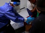 Volunteer paramedic, Kevin Garcia, checks the level of oxygen of a man with symptoms of the coronavirus disease (COVID-19)