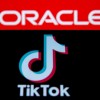 Smartphone with Tik Tok logo is seen in front of displayed Oracle logo in this illustration taken