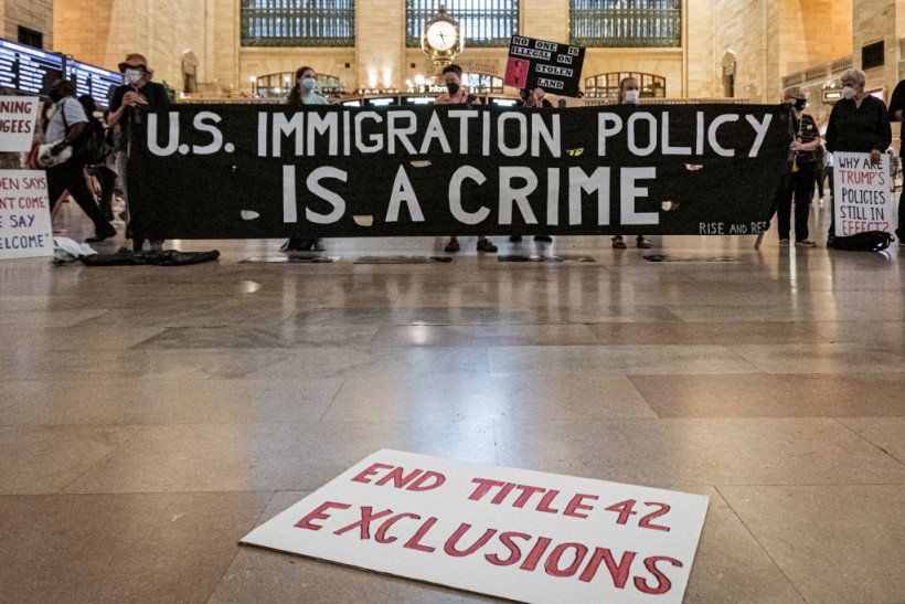 Protesters seen holding a banner reading US IMMIGRATION...