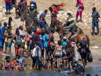 Border agents on horses with Haitian migrants