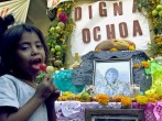A child is seen in front of an altar honoring Dign