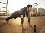 Man in Gray Jacket Doing Push-Ups During Sunrise