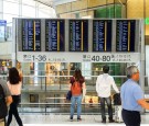 People Standing Near Airport Departure Board