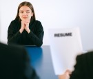 Woman in Black Long Sleeve Shirt Sitting Having Interview