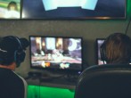 selective focus photography of two persons playing game in front of monitors