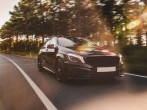 Front view of a black luxury sedan on the road.