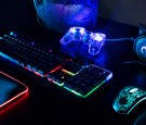 View of illuminated neon gaming keyboard setup and controller