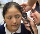 Dr. Michael Paul, with the Pediatric Mobile Health Unit of Loyola University Medical Center, performs a physical exam for incoming fifth-graders on fourth-grader Bennita Correa outside David Burnham Elementary School May 11, 2004 in Cicero, Illinois.